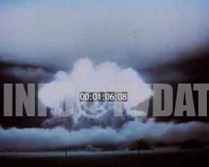 Wide-shot view of a massive nuclear explosion, capturing the towering mushroom cloud of smoke and fire, with an initial lens flare effect