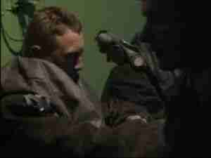 Men in breathing apparatus in a dim compartment, archival frame from Kursk submarine coverage.